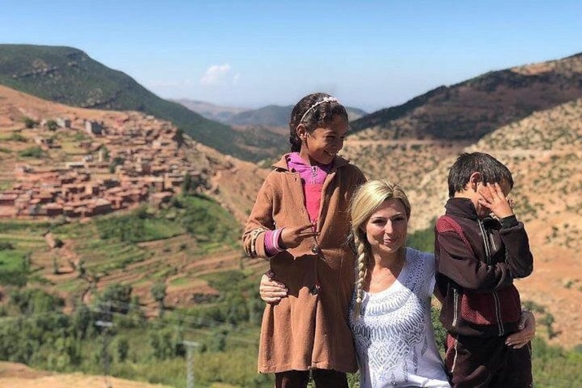 Un groupe de personnes se tient sur une colline, d’où l’on peut admirer une vallée avec des champs en terrasses et une chaîne de montagnes lointaine. 3