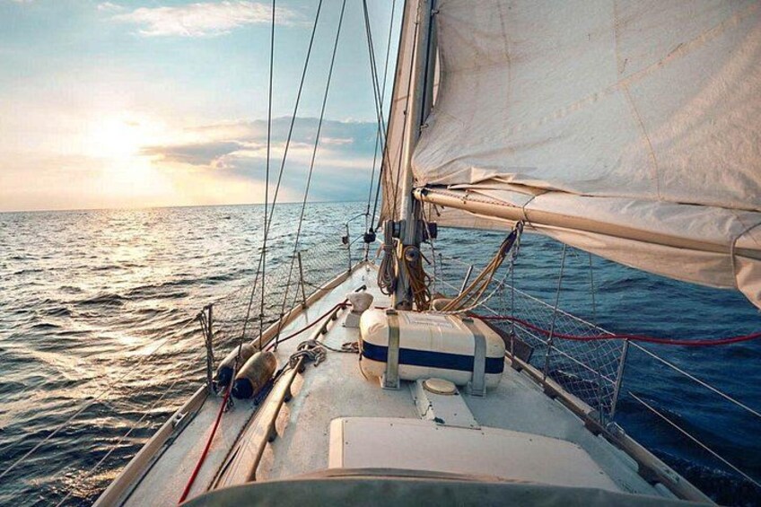 Un velero con vela blanca, cuerdas y un flotador en la cubierta. 5