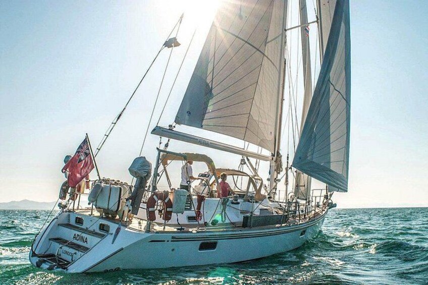Un voilier doté de plusieurs voiles, transportant des passagers et arborant un drapeau. 3