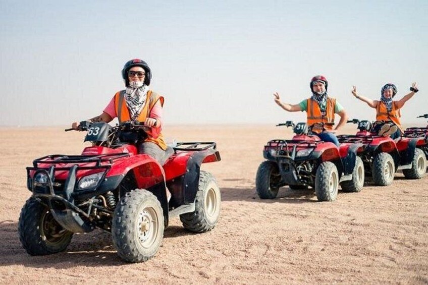 Drei Personen fahren mit Quads durch eine Wüstenlandschaft. 3