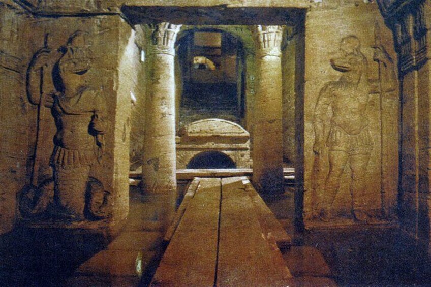 Un ancien couloir de pierre orné de hiéroglyphes, avec une porte d’entrée au centre. 4