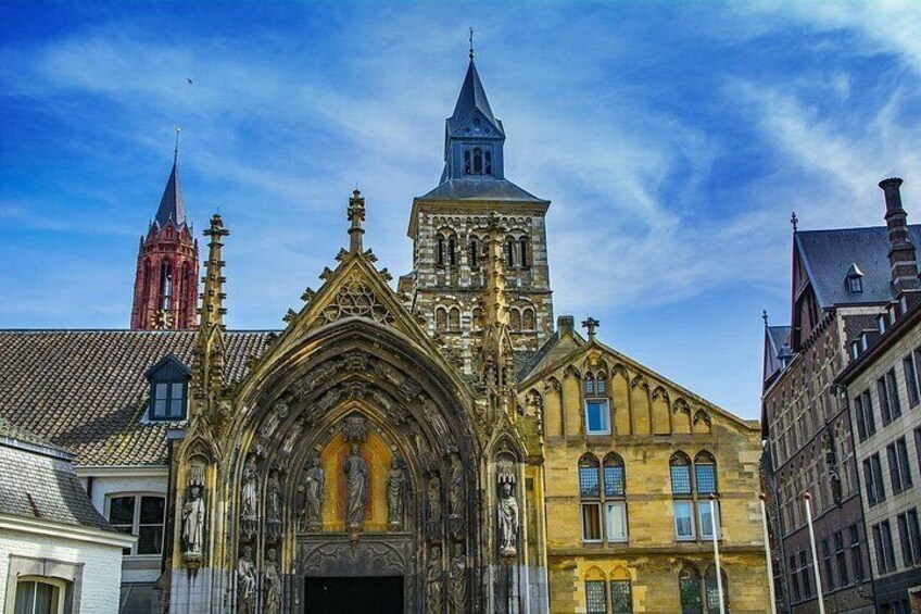 A historic church with intricate Gothic architecture, a prominent spire, and a red tower in the background. 4