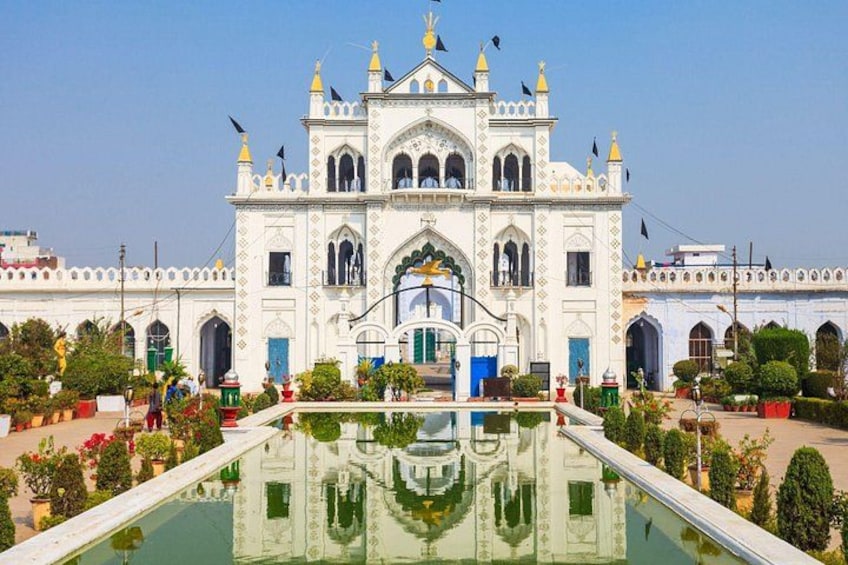 A white building with a central archway and a reflection pool in front. 1