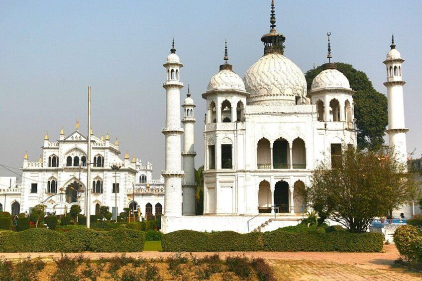 A white building with domes and minarets, surrounded by greenery. 5