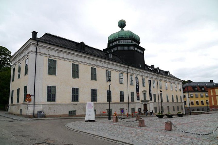 A historic building with a green dome and a white facade. 2