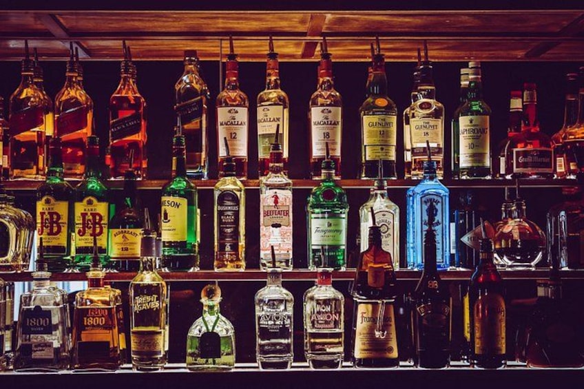 A variety of liquor bottles on shelves. 4