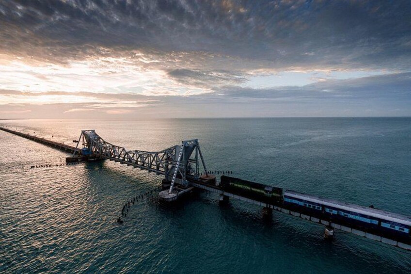Een brug over het water, met een zonsondergang op de achtergrond. 1