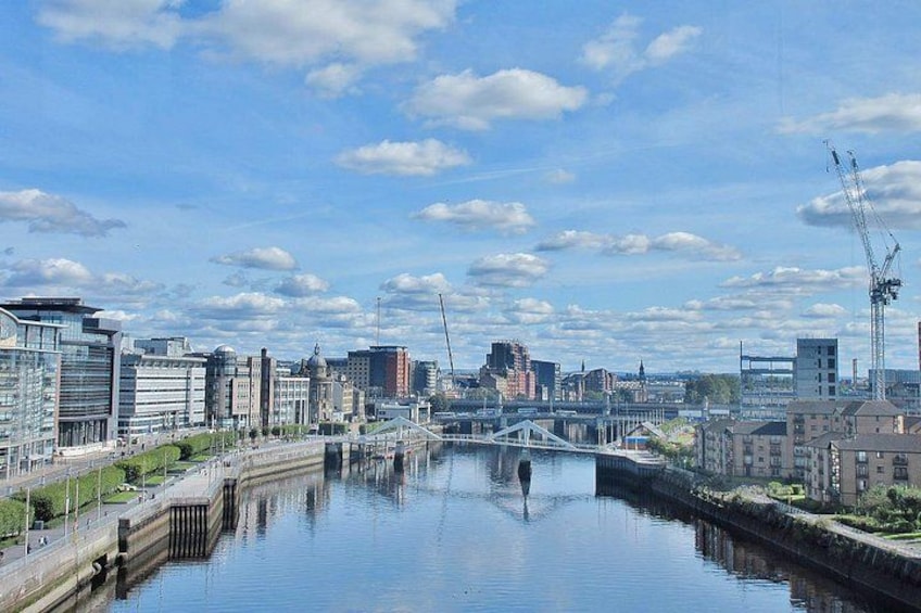 A river with buildings on both sides, a bridge, and a crane in the distance. 3