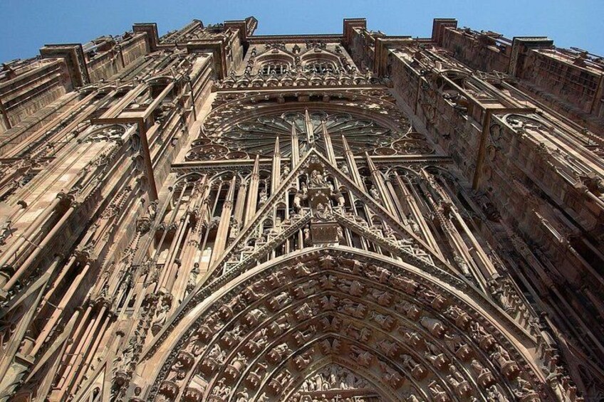 A detailed view of a Gothic cathedral's facade with intricate stone carvings and a large, ornate entrance. 2