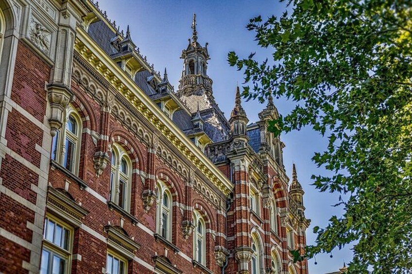 A historic building with ornate architecture, including a clock tower and detailed brickwork. 2