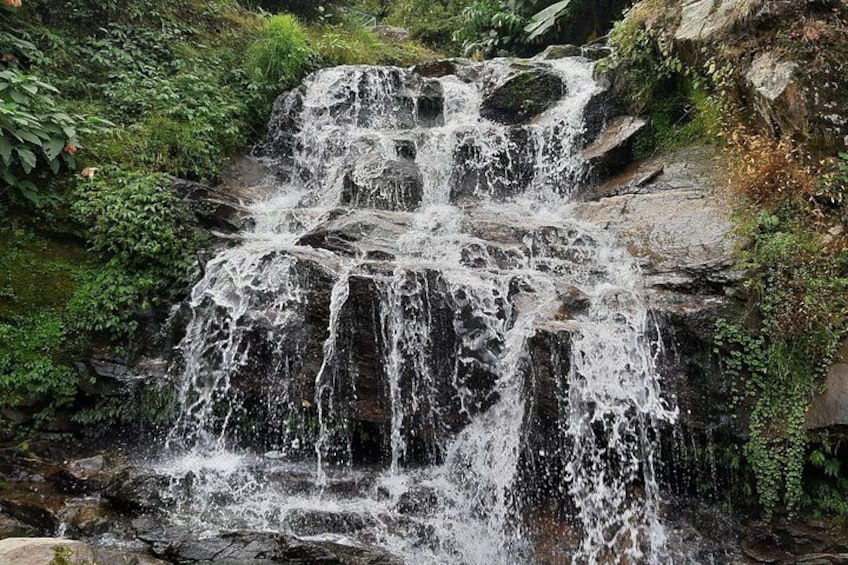 A multi-tiered waterfall surrounded by lush greenery. 2