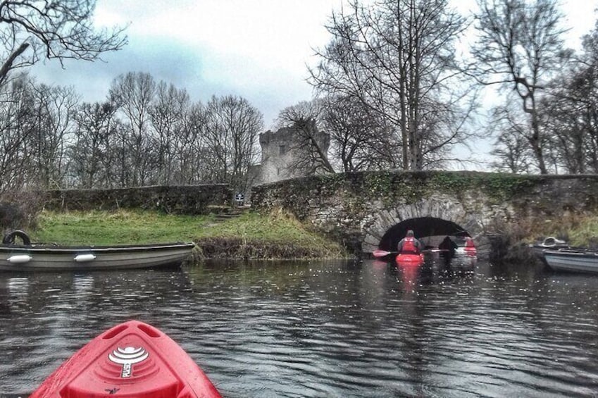 A red kayak on a river, a bridge, and a castle in the background. 4