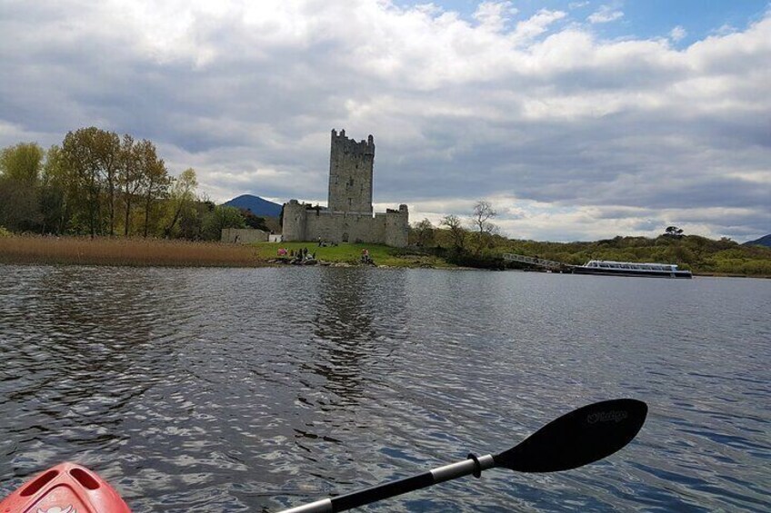 A castle on a river with a paddle in the foreground. 2