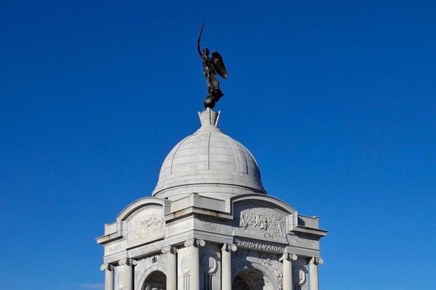 Une statue surmontant un dôme orné d’inscriptions. 4