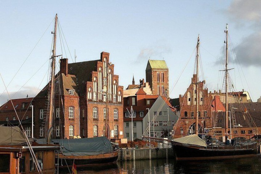 En havn med historiske bygninger og både. 1