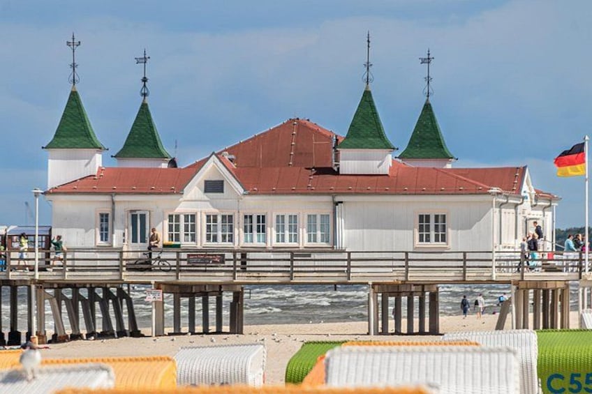 A coastal building with green roofs and a flag. 1