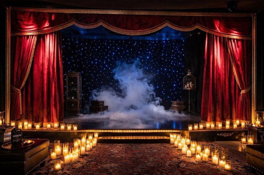 A stage with red curtains, a starry backdrop, and candles. 5