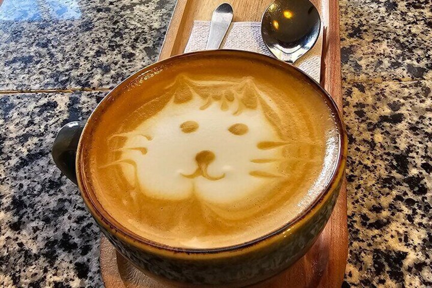 A cup of coffee with latte art on a granite countertop. 3