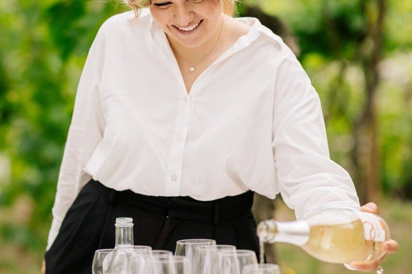 Iemand giet een vloeistof uit een fles in een glas. 1