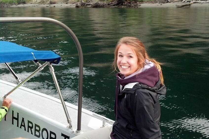 Una persona en un bote con cubierta azul y baranda metálica, con agua de fondo y un muelle. 2