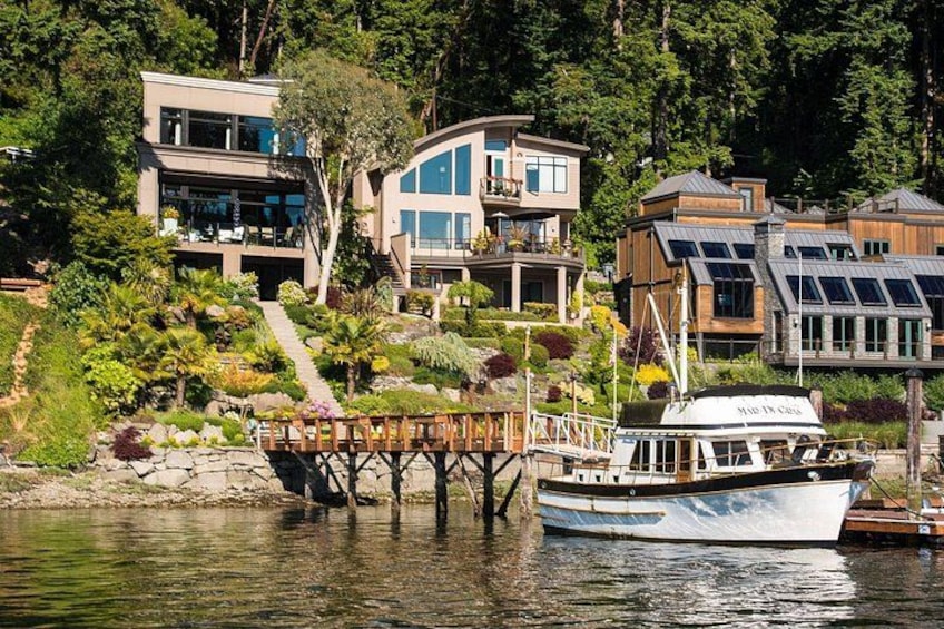 A waterfront with modern houses, a dock, and a boat. 3