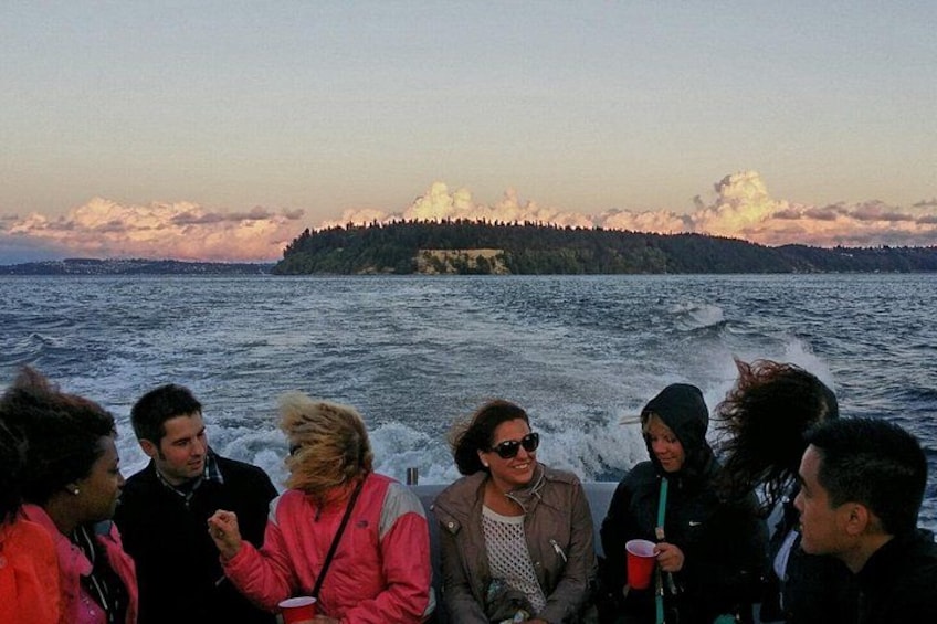 A group of people on a boat with a forested island in the background. 4