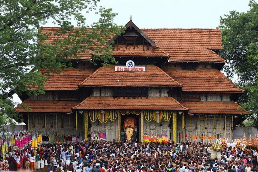 A traditional multi-tiered building with a tiled roof, surrounded by a crowd of people. 1