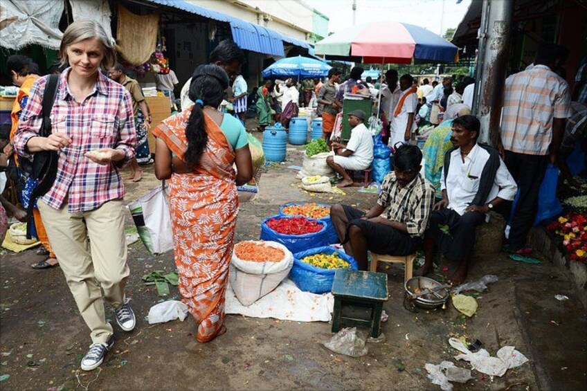 A bustling outdoor market with people shopping and vendors selling goods. 2