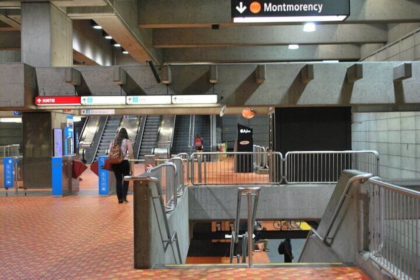 An underground station with escalators, a sign for Montmorency, and a tiled floor. 4