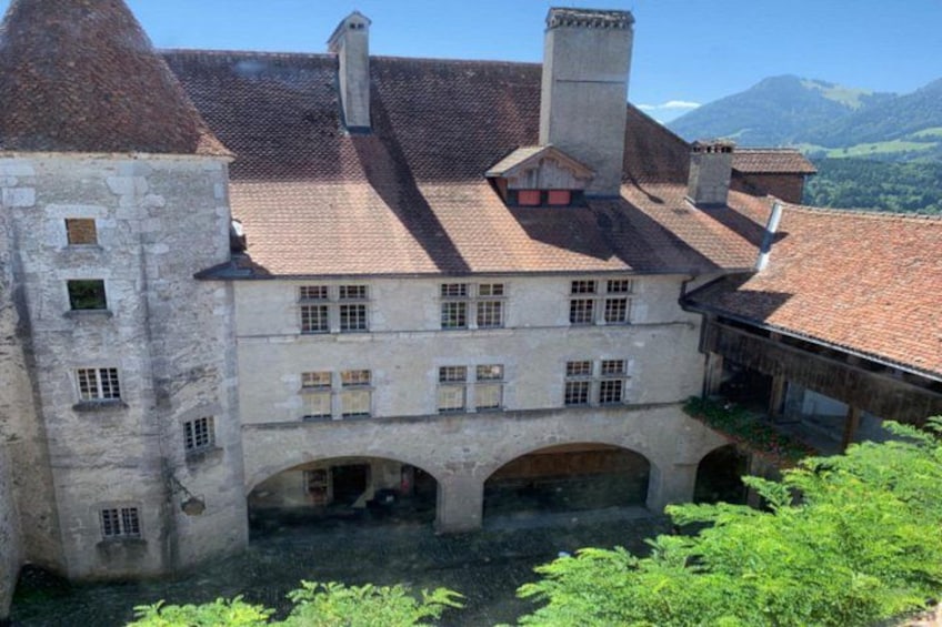 A historic building with a tiled roof, arched windows, and a courtyard. 5