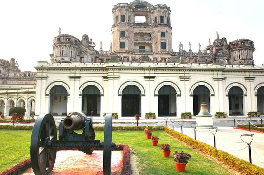 A historic building with arched windows and a large cannon in the foreground. 1