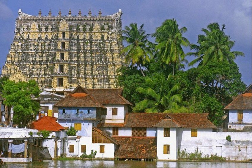 A historic temple with intricate carvings, traditional houses, and palm trees. 5