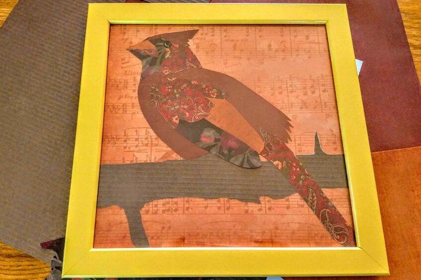 A framed artwork of a bird on a branch with a yellow frame. 4