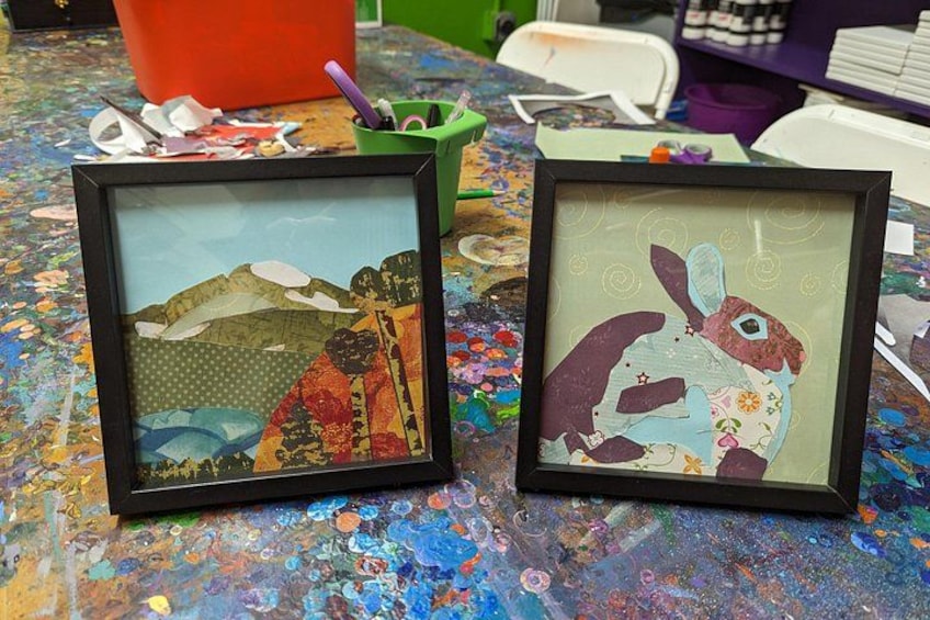 Two framed artworks on a table with a colorful, paint-splattered surface. 3
