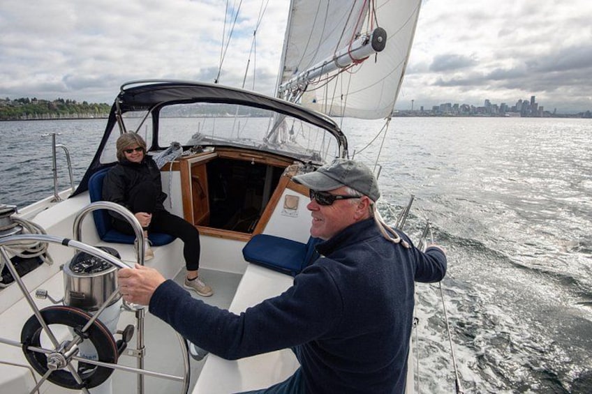Un velero con dos personas a bordo, una manejando y otra sentada. 5