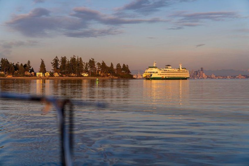 Un ferry en aguas tranquilas con el horizonte de una ciudad al fondo. 3