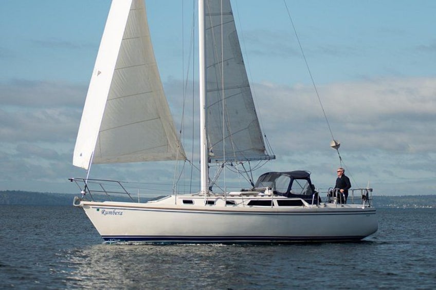 Un velero llamado 'Rumberra' en aguas tranquilas bajo un cielo despejado. 4