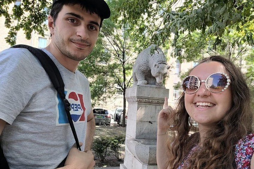 Two people standing in front of a statue of a lion. 5