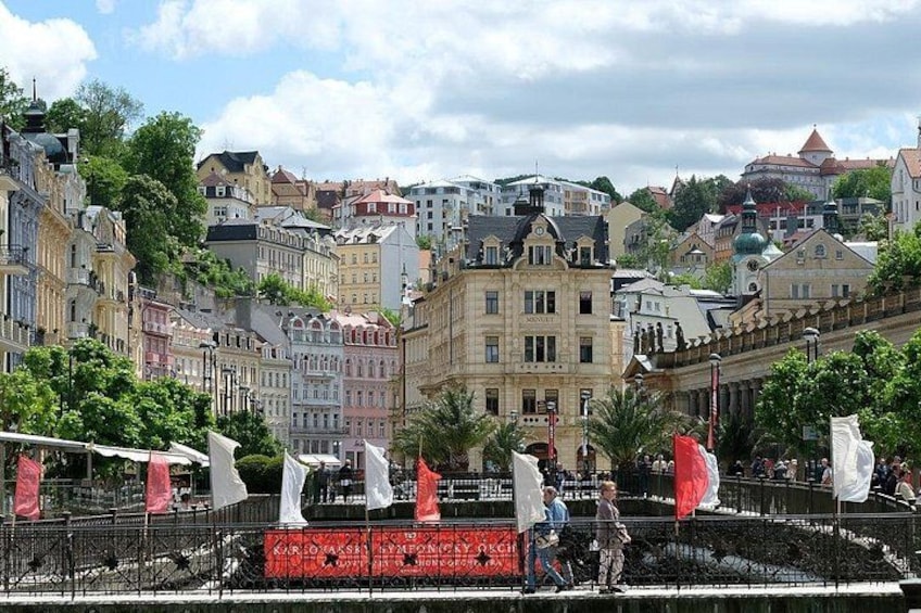 A cityscape with historic buildings, a river, and flags. 2