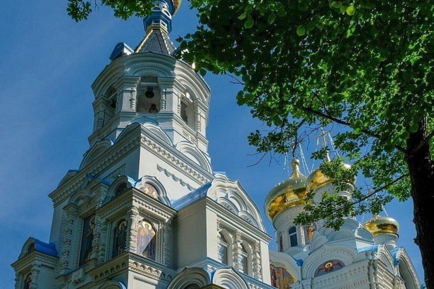 A church with ornate architecture, including a bell tower and golden domes. 1