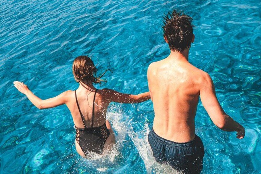 Two people swimming in clear blue water. 4