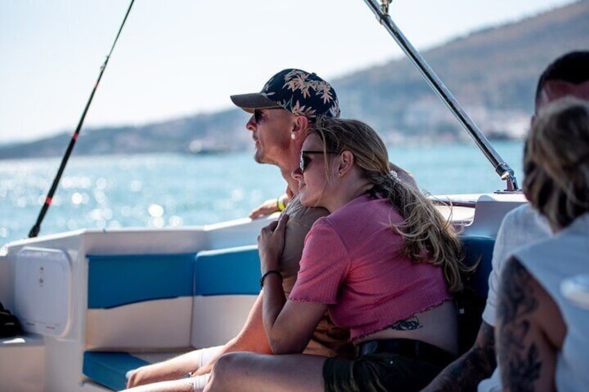 Menschen in einem Boot mit blau-weißer Innenausstattung, einer Angel und einem Gewässer im Hintergrund. 4