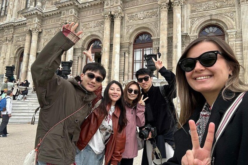 Un groupe de personnes posant devant un bâtiment historique à l’architecture richement décorée. 3