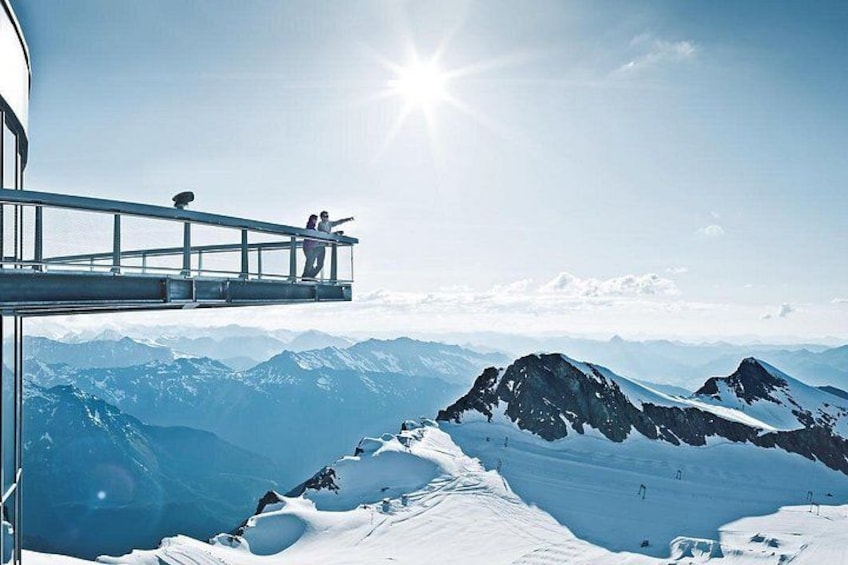 A snow-covered mountain landscape with a glass bridge and a clear sky. 2