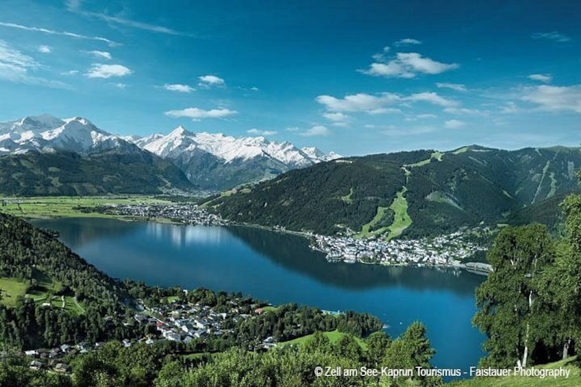 Un lago rodeado de montañas, un pueblo pequeño y un bosque denso. 1