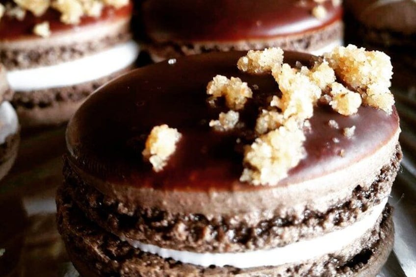 A stack of layered desserts with a chocolate glaze and crumbled topping. 3