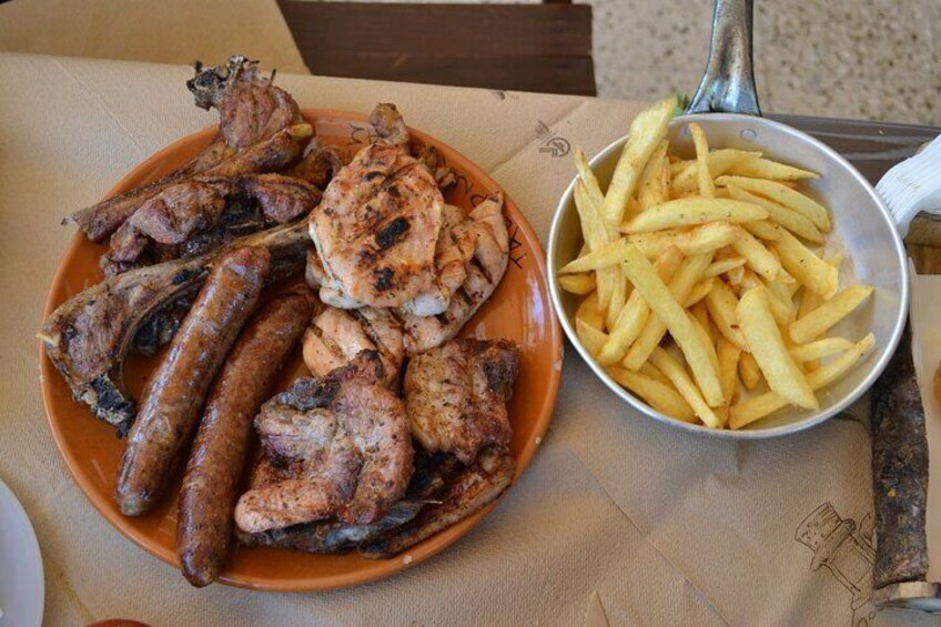 A plate of grilled meats and a bowl of French fries. 5