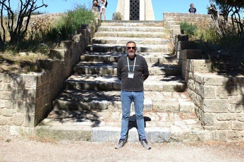 A man standing on stone steps with a building in the background. 2