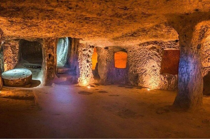 An underground cave with stalactites, a stone bench, and a small window. 3