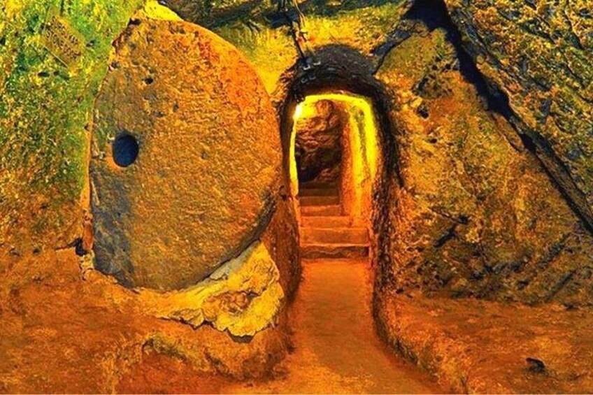 A stone tunnel with a staircase leading into a cave. 4